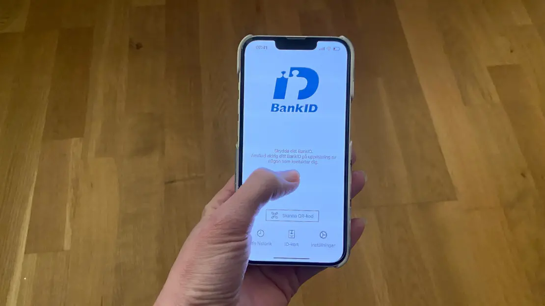 En hand håller en telefon som visar BankID