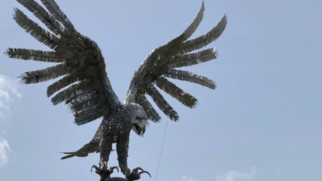 Staty av örn i silvrig metal.