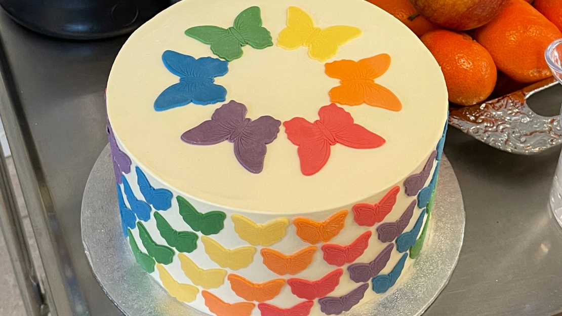 tårta dekorerad med fjärilar i pride-färger