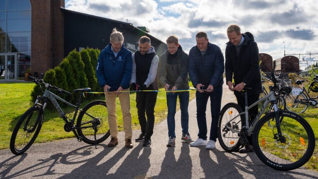 Företrädare för kommuner och Västkuststiftelsen klipper ett band uppänd mellan två cyklar på cykelvägen vid Glasets Hus i Limmard.