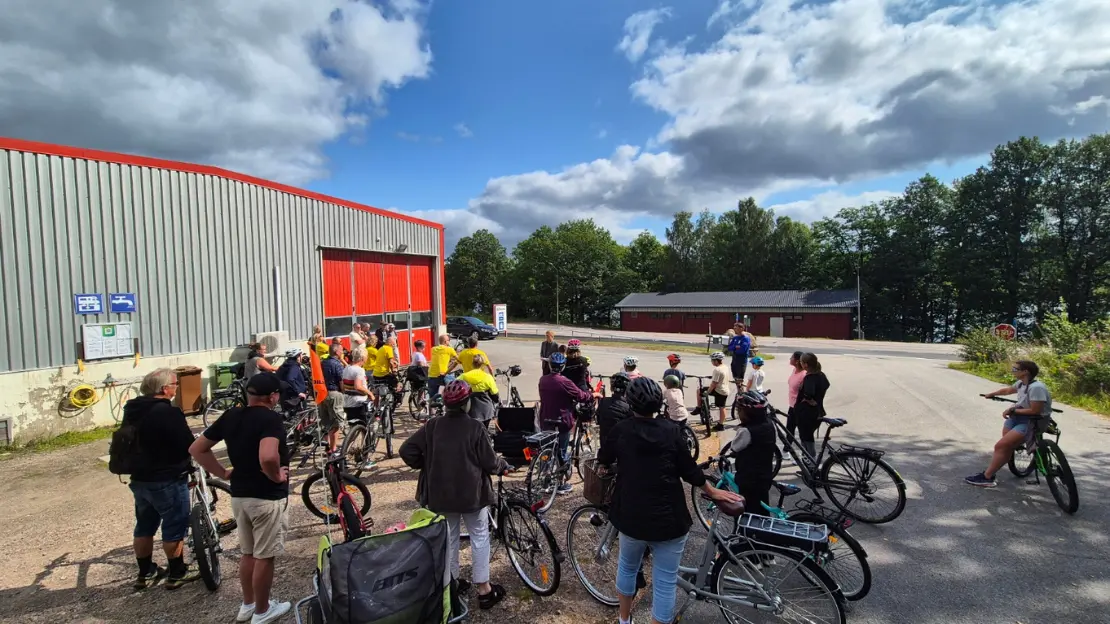 En grupp cyklister står vid starten av Överlida grus och Transport.