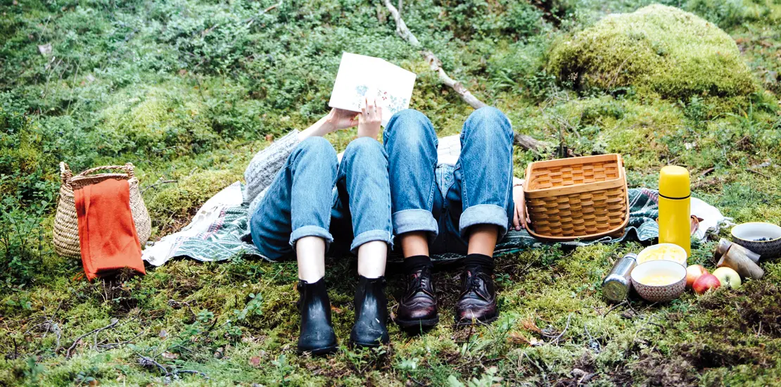 två personer ligger ner och vilar efter en picknick