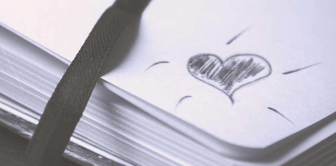 ett litet hjärta ritat i hörnet på en anteckningsbok
