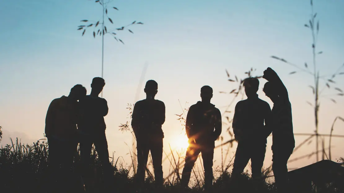 silhuetter av sex ungdomar i solnedgången