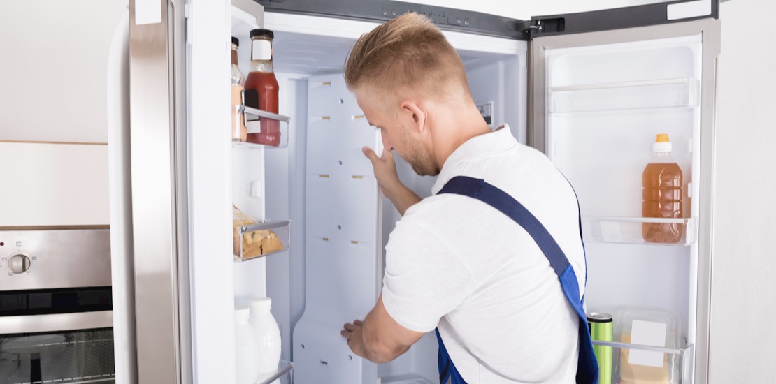 Person lagar något i ett kylskåp.