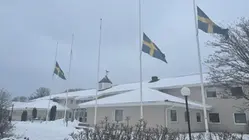 kommunhuset i snö, svenska flaggan på halvstång