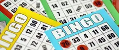 Flera blad Bingo i olika färger ligger på varandra, med några siffror duttade.