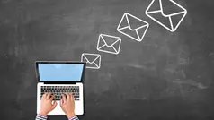 Händer skriver på tangentbordet på en laptop, ovanför den svävar symboler för kuvert.