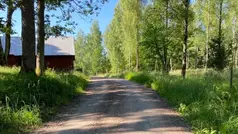 En grusväg jämte en lada i en landsbygd.